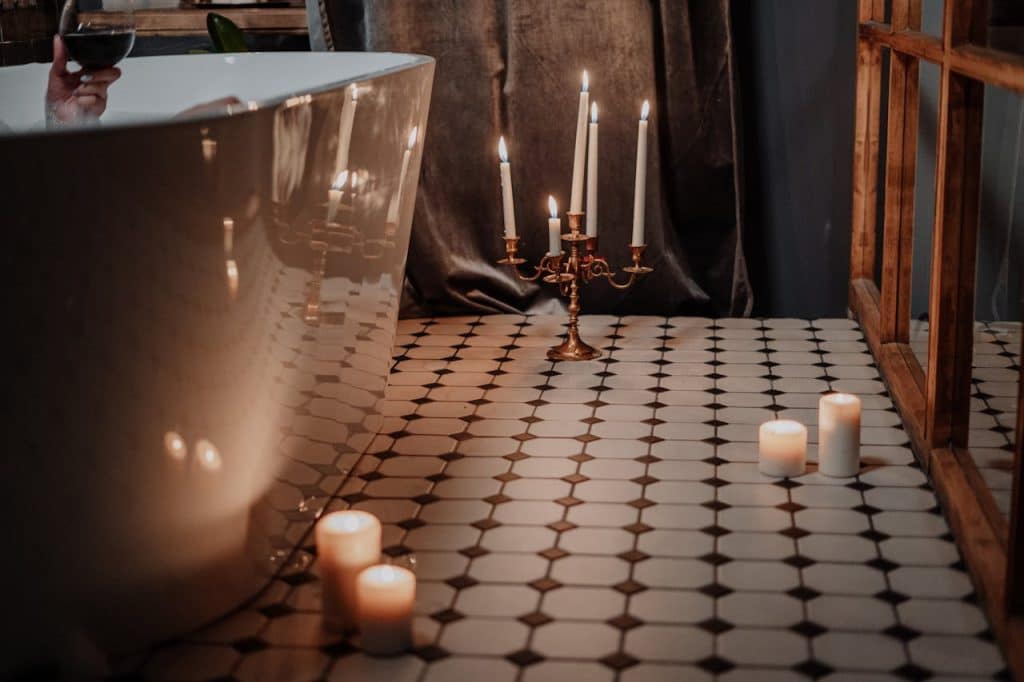 Lighted Candles on Table Near Glass Cup